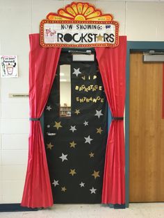 a door decorated with red curtains and stars in front of a sign that reads, now showing rockstars