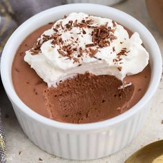 two white bowls filled with chocolate pudding and whipped cream