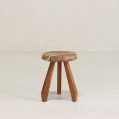 a wooden stool sitting on top of a white floor