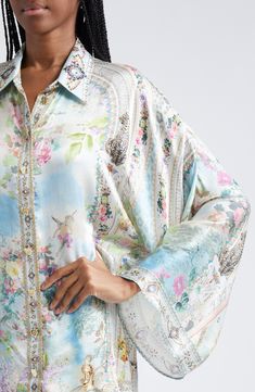 The beauty of ancient Egypt comes to life in an enchanting garden print on this fluid silk shirt adorned with heart-shaped buttons and hand-placed crystals. 30" length (size Medium/Large) Front button closure Point collar Long sleeves 100% silk Dry clean Imported Designer Clothing Luxury Printed Blouse For Spring, Luxury Silk Shirt With Floral Print, Elegant Silk Blouse With Digital Print, Enchanting Garden, Garden Print, Wide Sleeves, Silk Shirt, Ancient Egypt, The Beauty