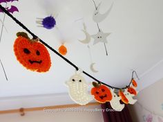 halloween decorations hanging from the ceiling with bats and pumpkins