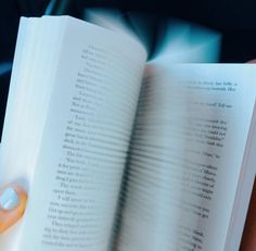 a person is holding an open book in their left hand and the pages are white