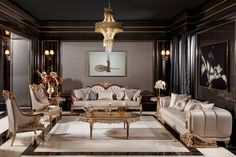 an elegant living room with white couches and gold trimmings, along with chandeliers