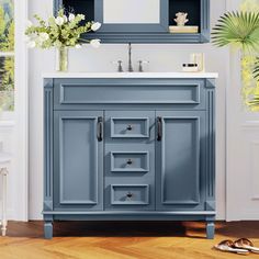 a bathroom vanity with blue painted cabinets and drawers in front of a large mirror above the sink