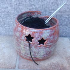 a crochet hook is hooked up to a yarn pot with stars on it