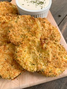 some fried food on a cutting board with a dipping sauce