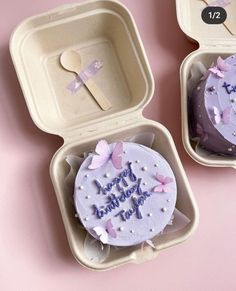 two cupcakes in plastic containers on a pink surface with the words happy birthday written on them