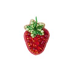 a beaded strawberry ornament with pearls and green leaves on it's side