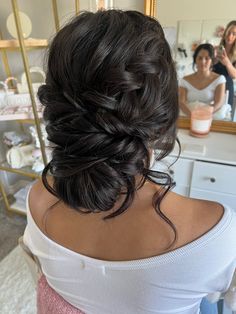 a woman is getting her hair done in front of a mirror