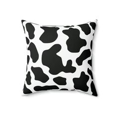 a black and white cow print pillow on a white background