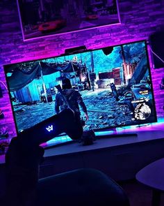 a person standing in front of a tv with purple lighting on it's screen