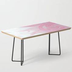 a pink and white coffee table with black metal legs on an isolated grey background,