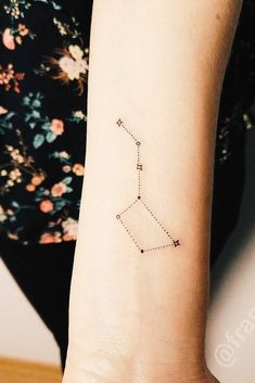 a woman's arm with a small star tattoo on it