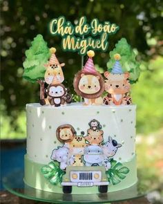 a birthday cake with animals on it and the words cha do sono miguel written in spanish