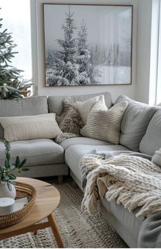 a living room filled with furniture and a christmas tree in the window sill next to a couch