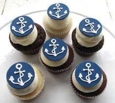 cupcakes decorated with blue and white frosting are arranged on a glass plate