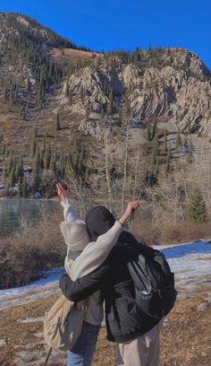 two people are looking up at the mountains