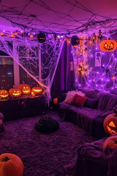 a living room decorated for halloween with purple lights and pumpkins on the couches