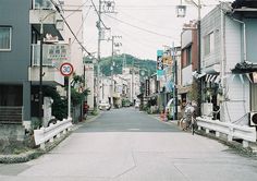 an empty street lined with buildings and power lines