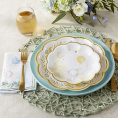 a table setting with plates, silverware and flowers