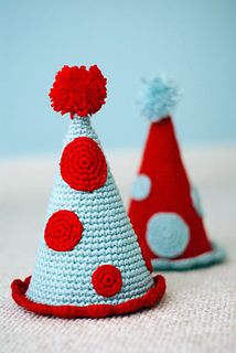 two crocheted party hats with red and white dots on them, one in the shape of a cone