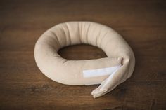 a close up of a cloth ring on a wooden table with white tape around it