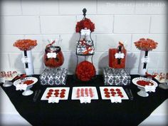 a black table topped with red and white desserts