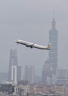 an airplane is flying over the city skyline