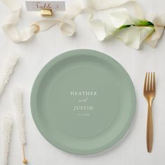 a plate with a name on it next to some forks and spoons, napkins and flowers