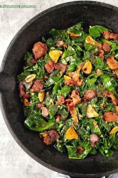 a pan filled with spinach and bacon on top of a table