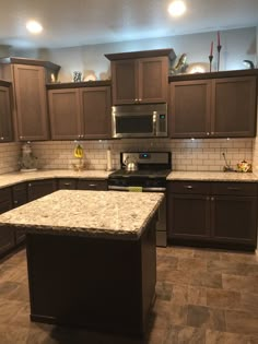 a kitchen with granite counter tops and brown cabinets