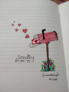 an open notebook with a drawing of a mailbox and hearts coming out of it