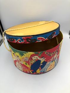 "Great news! All orders from my shop that total $35 or more get free shipping to the US!! Check out the rest of my shop to mix and match items: https://themagicwithin.etsy.com This listing is for a fabulous vintage hat box. Made of cardboard with a cream rope handle, it depicts a Marie Antionette style masquerade ball. The box is in quite good condition for its age. There is wear on the paper edges. The inside of the box is clean and would be perfect for a fashionable way to store your items. Please see video and all pictures for condition and message me with any questions. Measures about 13\" across x 6-1/2\" tall.  Actual coloring may vary slightly due to lighting, camera and monitor settings. Shipping costs are calculated by Etsy based on the size of the shipping box, the weight of the Vintage Hat Boxes, Reduce Reuse Recycle, Hat Boxes, Shoe Bags, Wooden Christmas Ornaments, Vintage Hats, Hat Box, Bowl Fillers, Vintage Hat