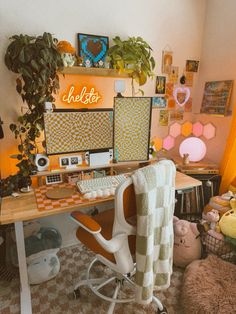 a desk with a chair, computer and stuffed animals on it in front of a window