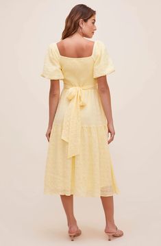 A dress that looks like a poem! The Sonnet Midi features a flattering V neckline that descends to a fitted bodice with a defined waist. Short puff sleeves and large bow accent at the back bring out the charm. Flowy midi-length skirt with a slightly ruffled trim. 100% Polyester Lining: 95% Polyester / 5% Elastane Self Tie Closure Dry Clean Only Puff Sleeve Midi Dress Back Tie Puff Sleeve Midi Dress, Midi Dress Style, Yellow Midi Dress, Astr The Label, Midi Length Skirts, Tie Styles, Puff Sleeve Dresses, Large Bow, A Poem