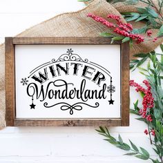 a wooden frame with the words winter wonderland printed on it next to red berries and greenery