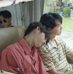 three people sitting on a bus looking at their cell phones while one person sits in the passenger seat