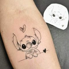 a small tattoo on the leg of a person with a heart shaped object in front of them