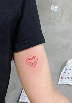 a person with a heart tattoo on their arm