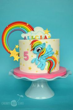 a birthday cake decorated with a rainbow and stars