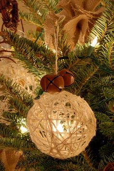 an ornament hanging from the top of a christmas tree with lights on it