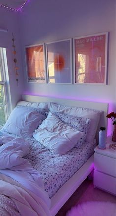 a bed with white sheets and pillows in a bedroom next to a window at night