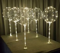 three lighted wine glasses sitting on top of a table