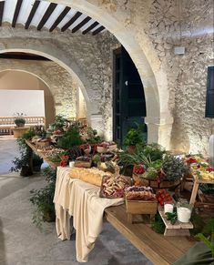 a table filled with lots of food on top of a wooden table next to an archway