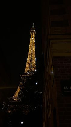 the eiffel tower lit up at night with lights on it's sides