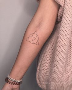 a woman's arm with a small tattoo on the left side of her arm