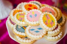 decorated cookies sitting on top of a white plate