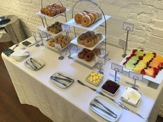 a table topped with lots of different types of donuts and fruit on trays