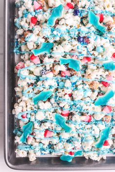 blue, white and red popcorn mix in a baking pan with sprinkles