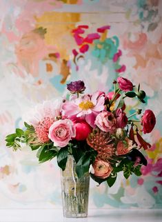 a vase filled with lots of flowers on top of a table